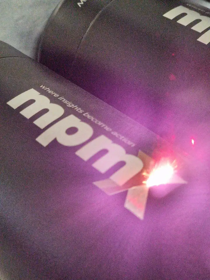 Laser graviert das mpmX-Logo auf eine schwarze Flasche